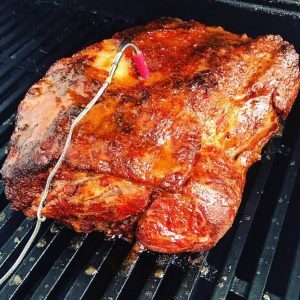 Pork butt cooking on a BBQ