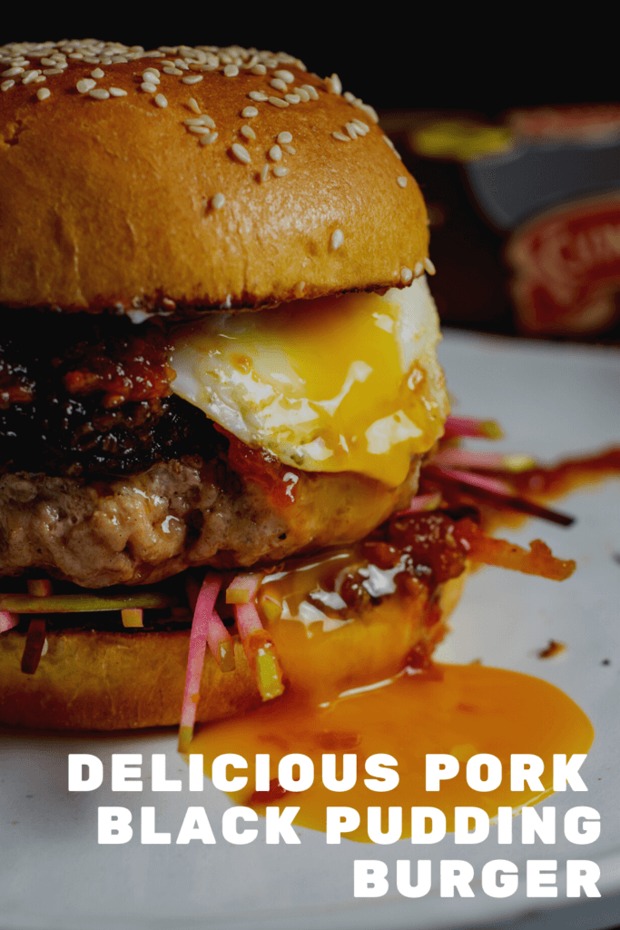 Close up of pork & black pudding burger with runny egg yolk. Clonakilty black pudding packet in background