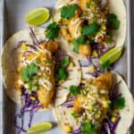 birdseye view of 3 crispy fish tacos on a tray