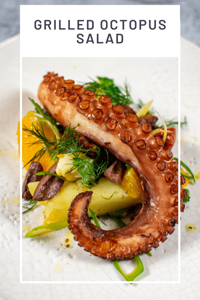 Grilled octopus salad on a white plate