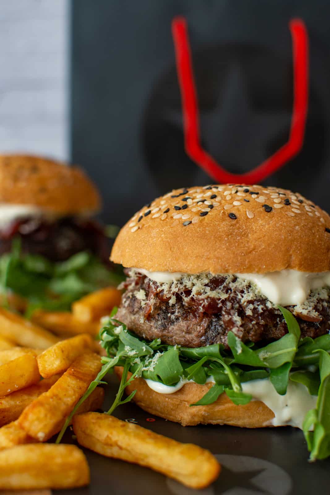 wagyu beef burger in forefront with chips and another burger in background