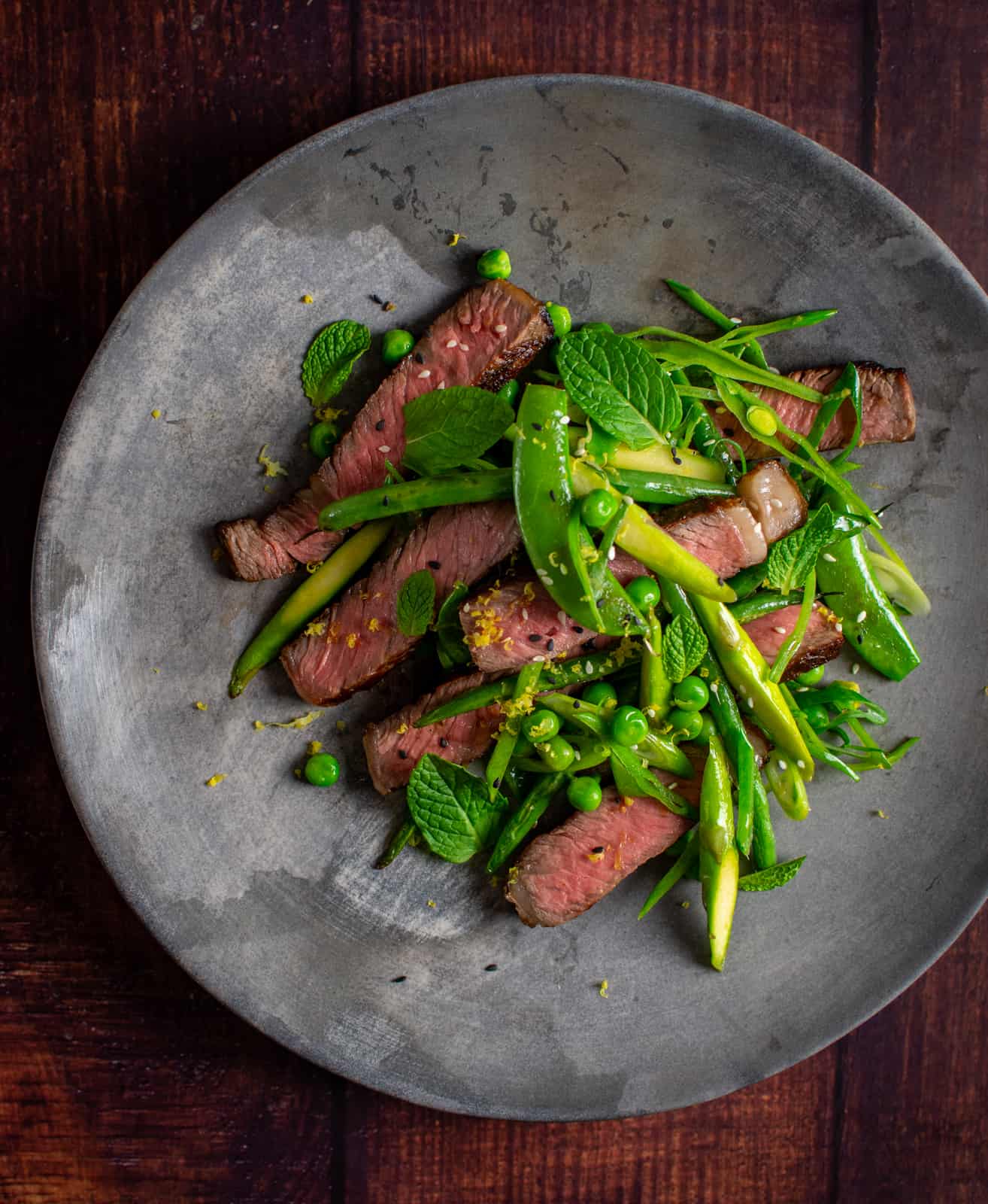 Grilled scotch steak and mixed greens salad on a plate 
