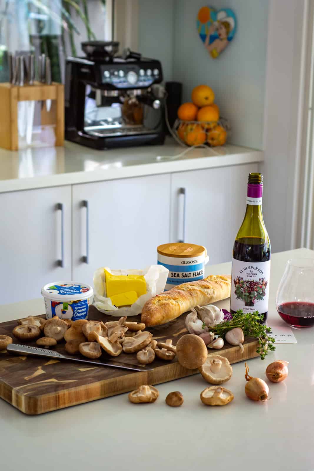 mushroom pate ingredients on a chopping board in the kitchen with view of kitchen counter top behind 