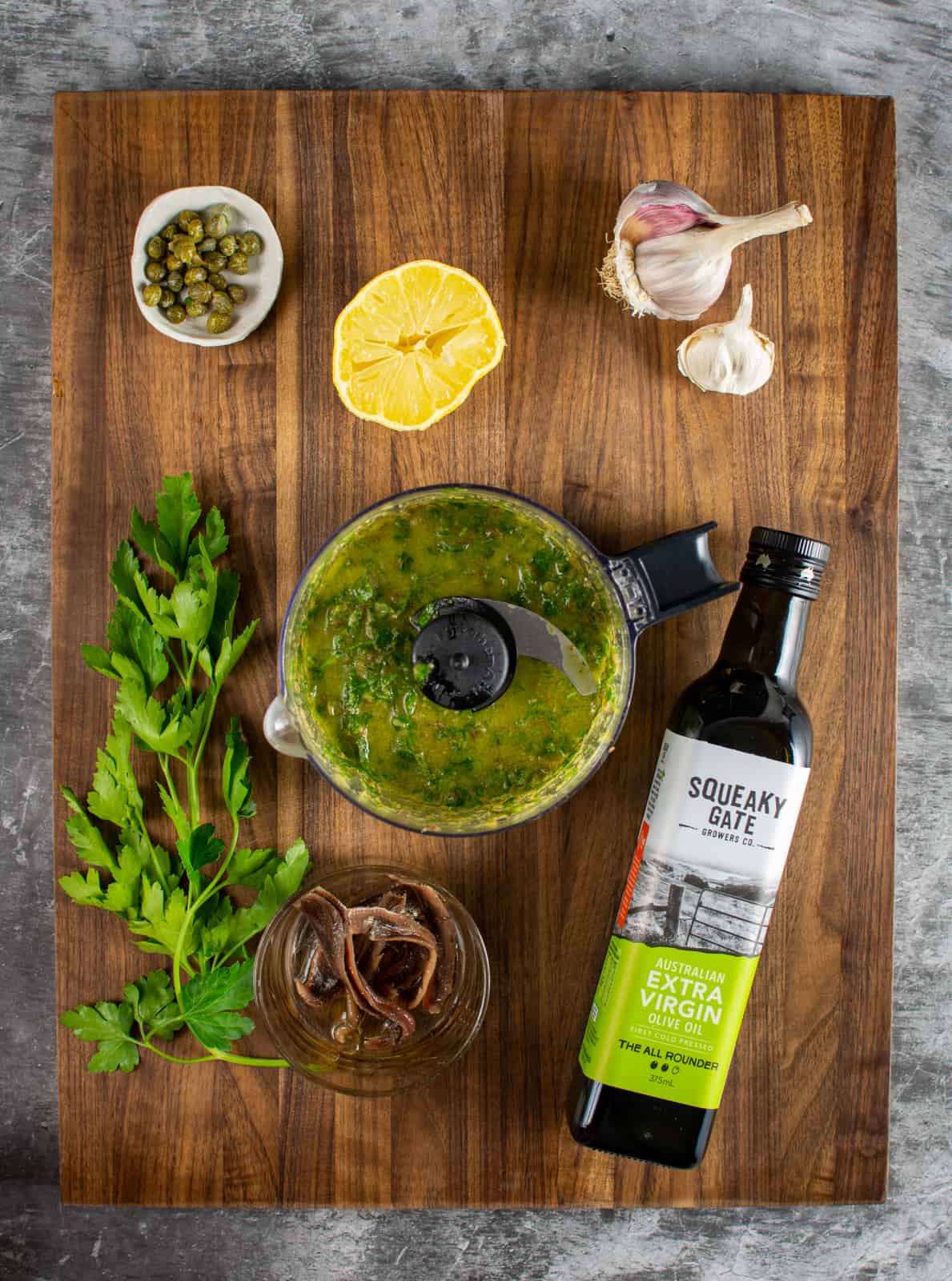 anchovy caper dressing ingredients on a chopping board 