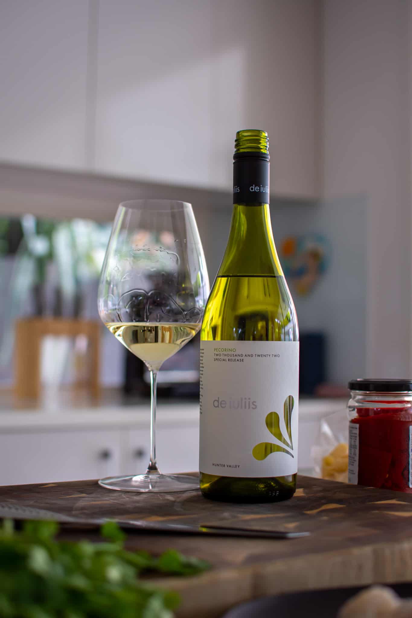 De iuliis pecorino wine with a glass next to it on a chopping board in the kitchen 