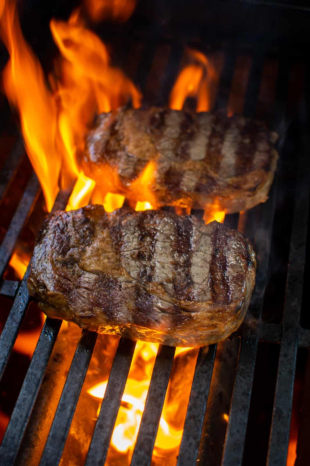 steaks on a BBQ with a flame